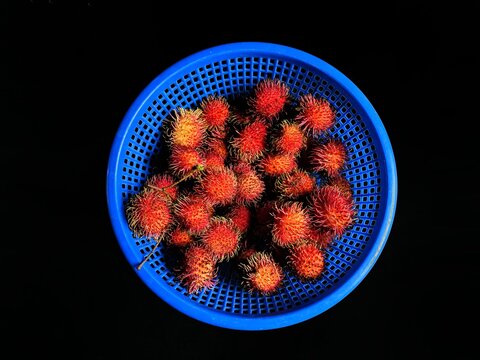 Rambutan fruit inside a basket with black background. exotic fruits from Asia