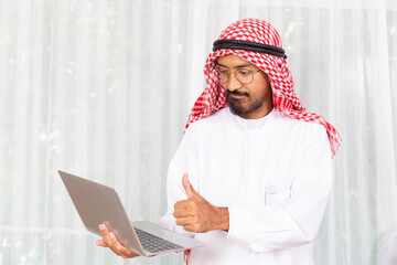 Arabian businessman smile and happy from message his computer notebook in his office