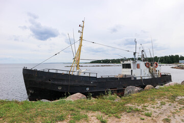 old abandoned fishing boat stuck in the stones