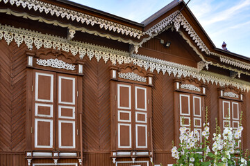 Carved window decorations, ornaments on the old house. Beautiful windows in a wooden house. Closed shutters. Window carving.