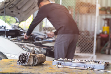 Starter motor of the car on working table in repair and maintenance garage