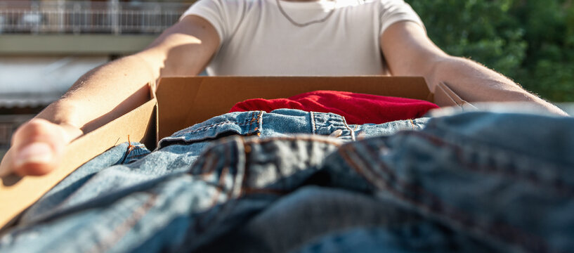 Woman holding card box with clothes inside. Donation Concept. Selective focus - Image of Eco-friendl