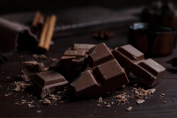 Pieces of delicious milk chocolate on wooden table