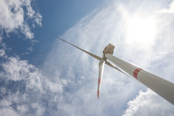 Modern wind turbine against cloudy sky, low angle view. Alternative energy source