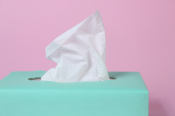Box with paper tissues on pink background, closeup