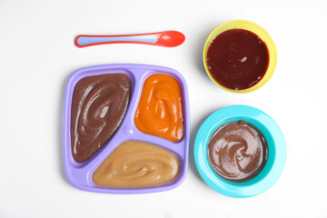 Flat lay composition with healthy baby food and spoon on white background