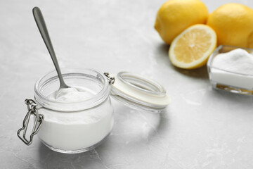 Baking soda and cut lemons on light marble table