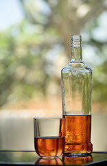 Fresh drink, bottle and glass of amber liquor