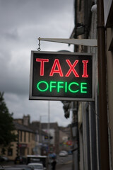 Red and green neon Taxi office sign. Bright neon lights advertising taxis