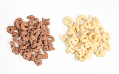 Two piles of cornflakes isolated on white background. Assorted chocolate cereals above