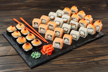 A large set of rolls on a dish with chopsticks.