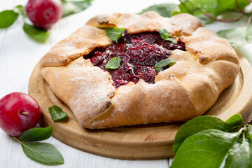 Traditional open pie with red plums.