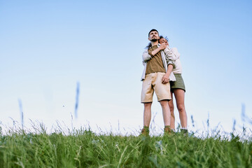 Happy young affectionate woman standing by her husband and embracing him