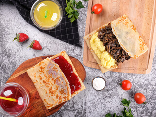 Shrovetide Maslenitsa. Traditional festival meal. Pancakes blini with meat and berry jam, flat lay...
