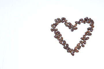 Roasted coffee beans in shape of hart on white background