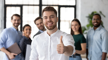 Smiling businessman company leader employee sales manager showing thumbs up smile looks at camera....