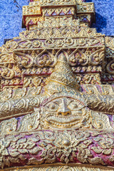 Beautiful sun-shaped human faces carving on the wall of the pagoda in the Buddhist temple, Chiang Mai, Thailand.