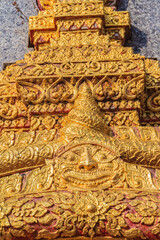 Beautiful sun-shaped human faces carving on the wall of the pagoda in the Buddhist temple, Chiang Mai, Thailand.