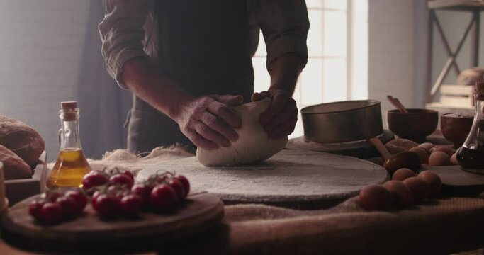 Hands of senior professional chef kneading floured dough for bread in bakery shop in the morning. Retiree enjoying new hobby making homemade bread close up 4k footage