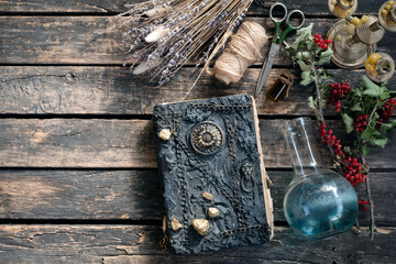 Spell book and magic potion on the old table. The witchcraft.