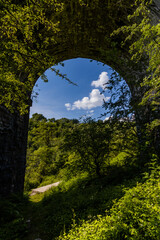 Arches underneath an old Victorian viaduct in a beautiful green rural setting (Pontsarn Viaduct, South Wales, UK)