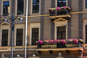 Fototapeta na wymiar a fragment of the facade of a building with balconies decorated with flowering petunias