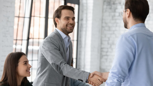 Executive manager welcoming investor during business formal meeting at office board room. Partners entities before closing deal start negotiations shake hands express respect showing loyalty concept