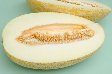 Cut half melon on a green background. Summer desserts