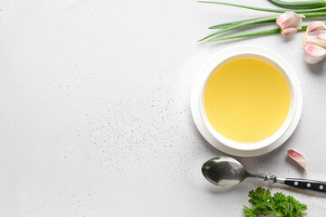 Chicken broth with parsley in bowl on white table. Copy space. Top view. Space for text.