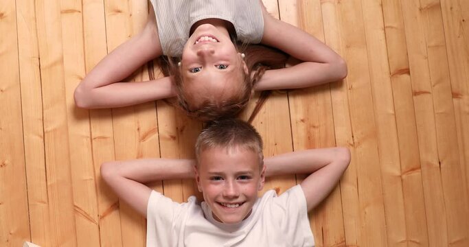 children lie on the floor and laugh. happy children look at the camera. childhood. lifestyle playing funny game together.