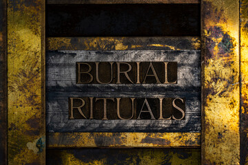 Burial Rituals text formed with real authentic typeset letters on vintage textured silver grunge copper and gold background