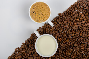 A Cup of coffee and a Cup of milk on coffee beans.