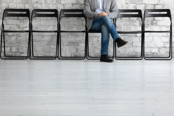 Man sit cross legs on chair in office bank corridor while wait turn with advisor or job interview feels tranquil and confident, has chance loan application approve, got position in company. HR concept