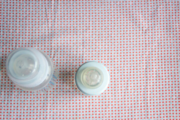 Feeding bottles with scale on dark background in kid's room