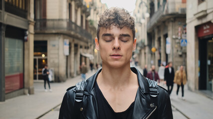 Portrait of young attractive casual man walking along street. New in town