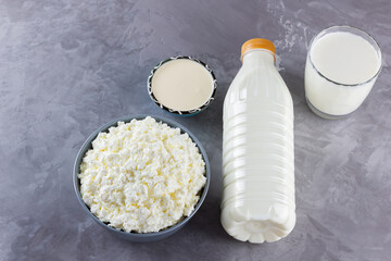 Various dairy products. Healthy dairy products on a gray background. Milk, sour cream and cottage cheese. Top view. Copy space