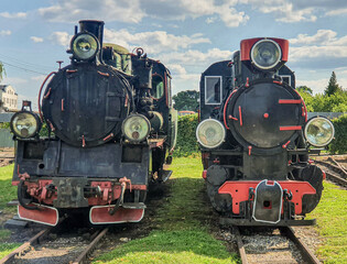 Fototapeta na wymiar Old steam engine locomotives on narrow gauge tracks in the museum