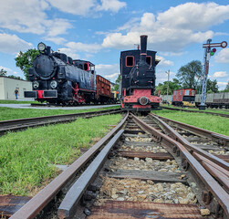 Fototapeta na wymiar Old steam engine locomotives on narrow gauge tracks in the museum