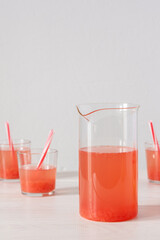 Summer refreshing grapefruit drink, jug and glasses with grapefruit pulp and juice and straws