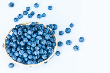 blueberries in bamboo basket on white background