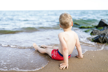 boy sits on the beach