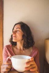 Obraz na płótnie Canvas A woman is enjoying morning coffee at home.