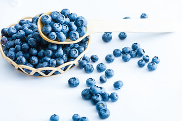 blueberries in bamboo basket on white background