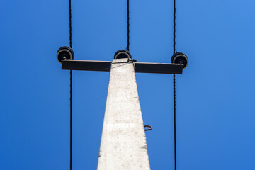 A power line pole against a blue sky.