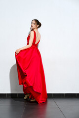 Portrait of girl in waiving red silk dress
