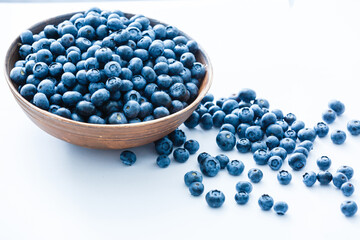 Freshly picked blueberries in wooden bowl. fresh blueberries on a white rustic table. selective focus.
