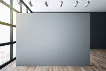 Minimalistic gallery interior with blank gray wall and city view.