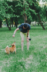 man is training a dog in a park, Young guy with dog on walk in summer park