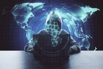 Hacker using laptop with digital blue world map hologram.