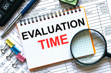 Text Evaluation Time on notepad with calculator, clips, pen on financial report